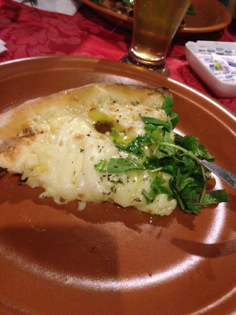 Pizza é colocada no prato de cerâmica / Crédito: Ana Elisa Teixeira